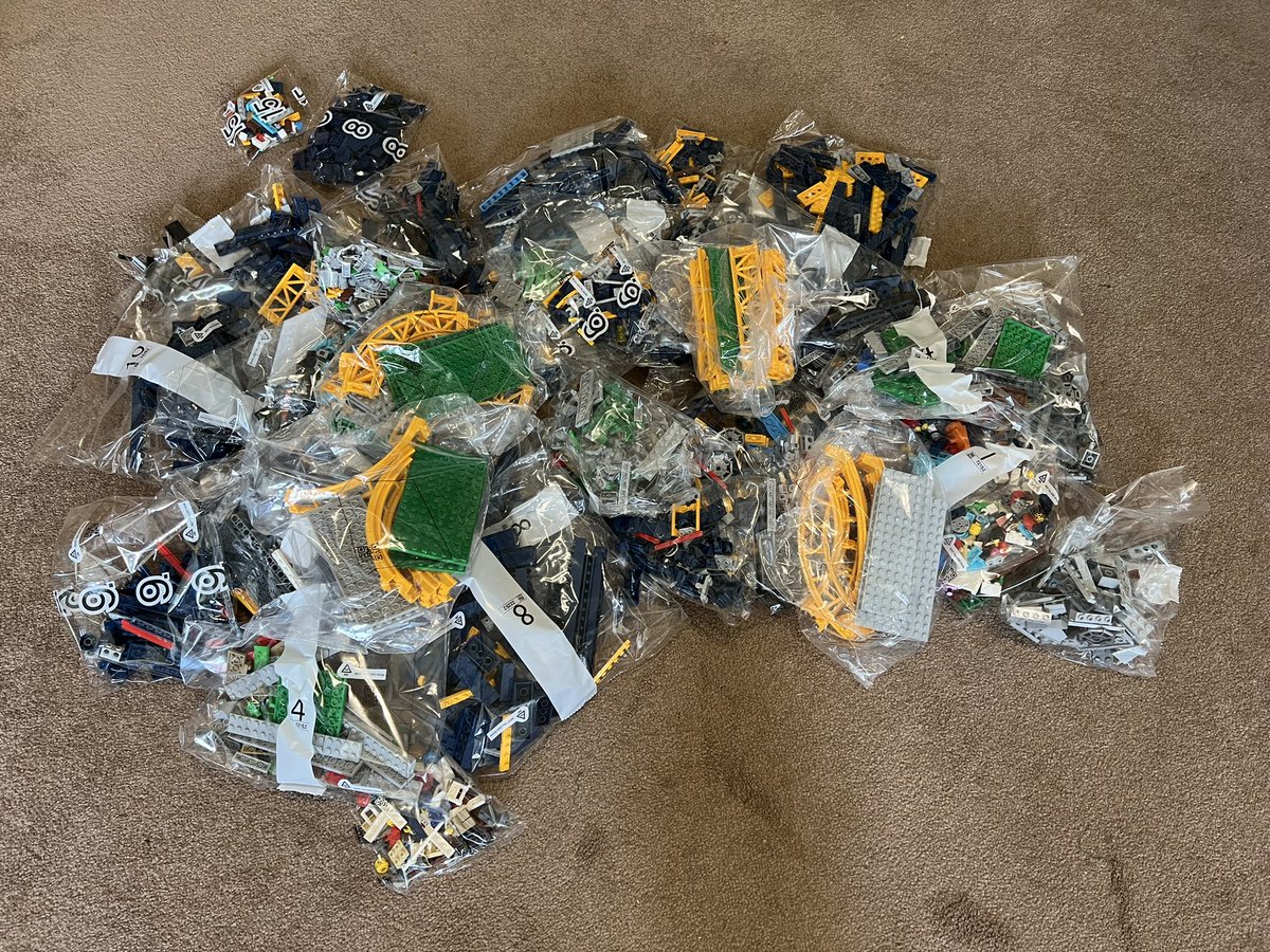 A disorganised pile of bags of lego on the floor