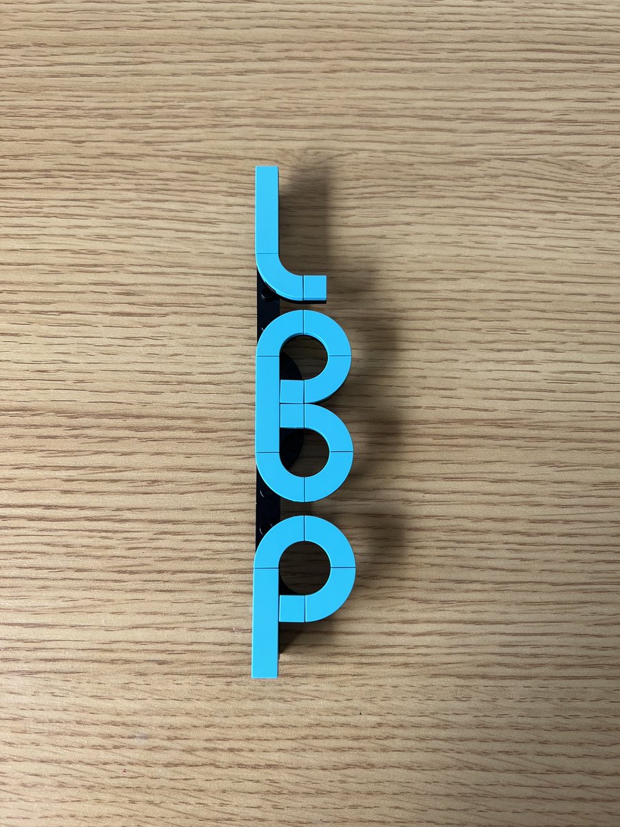 A small lego structure that spells the word loop out of light blue tiles. The Os are joined together and look almost like a capital B.