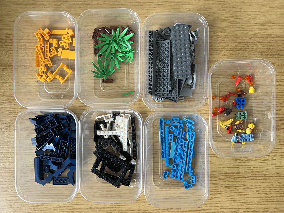 Seven tubs of lego sorted by colour. The yellow tub has a tiny piece of roller coaster track, and there’s a tub filled with pieces to make three minifigures.