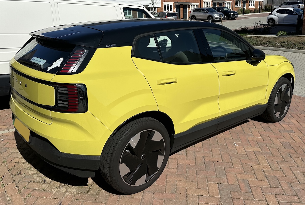 A bright yellow volvo EX30 as seen from the rear corner.